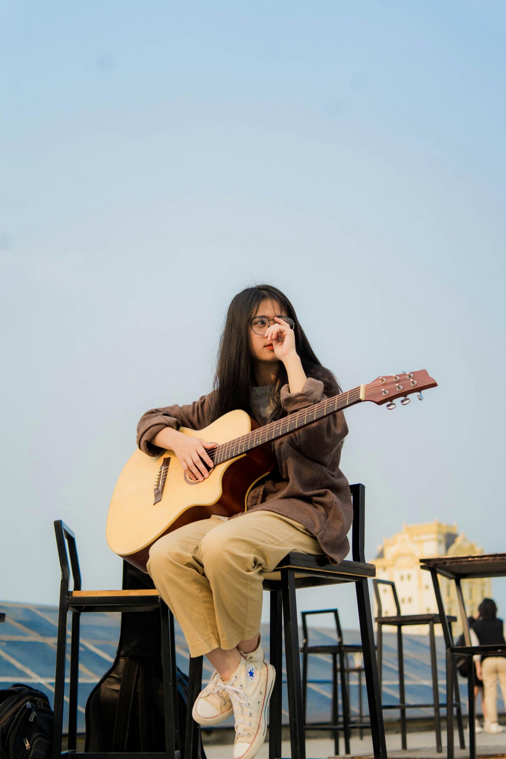 Woman Holding Guitar While Sitting